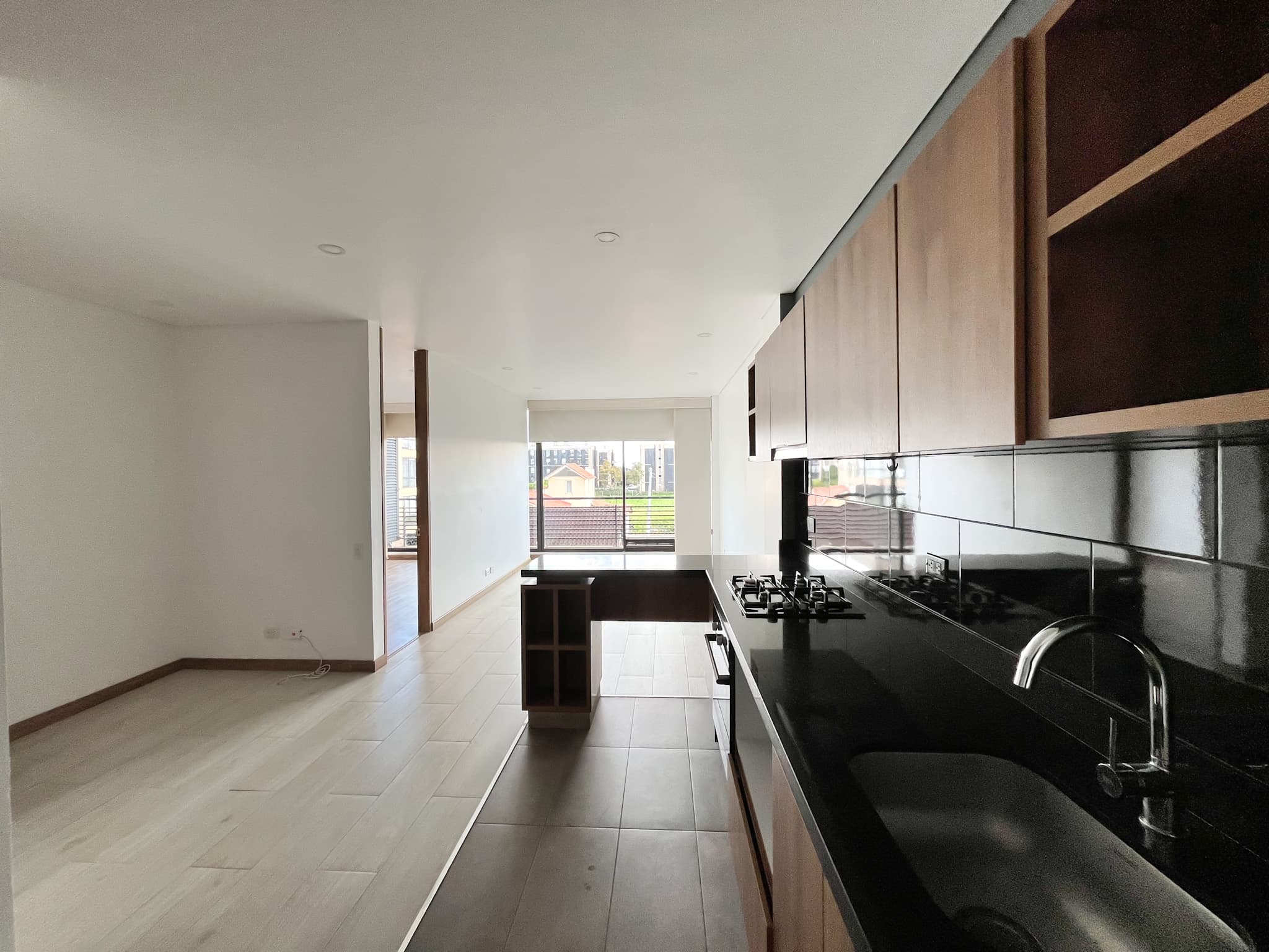 Planta abierta del apartamento con cocina integrada y piso en cerámica