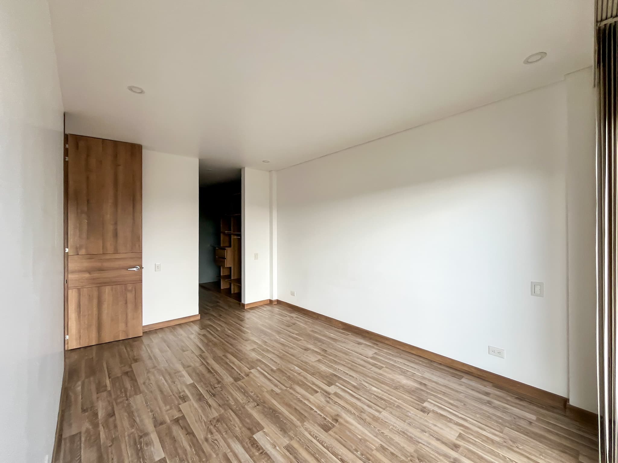 Habitación con piso en madera y acceso al vestier