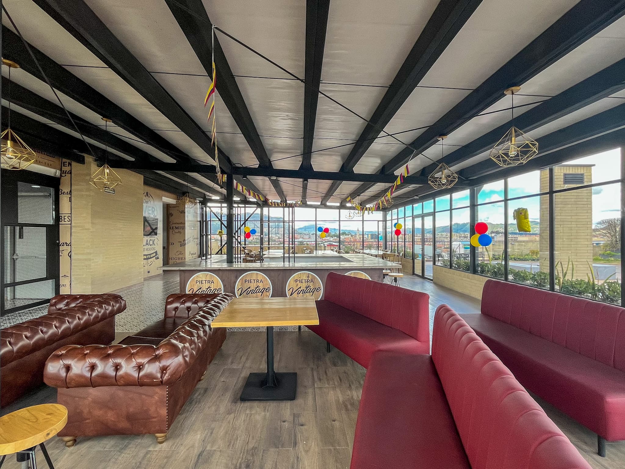 Salón del Vintage Bar — Sofás Chesterfield y ambiente vintage frente al ventanal.